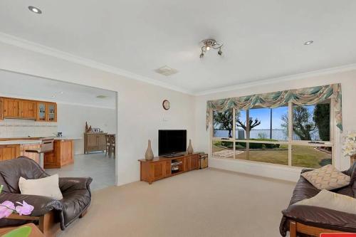 a living room with a couch and a television at Lakefront Beauty ! Pet friendly in Yarrawonga
