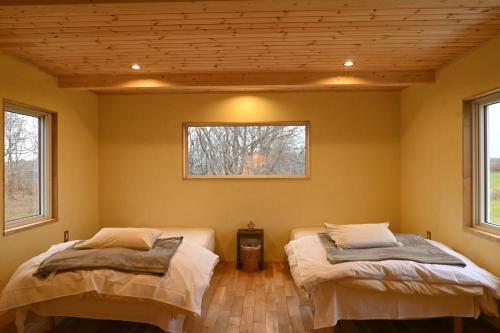 2 Betten in einem Zimmer mit 2 Fenstern in der Unterkunft Forest-House-Ranapirica - Vacation STAY 52421v 