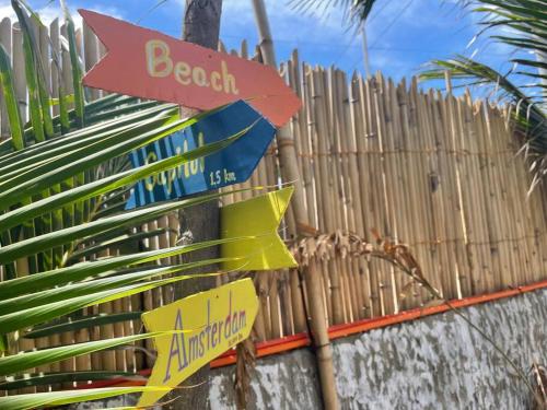 a wooden fence with street signs on it at Beachfront Glamping with Mini Pool Exclusive Property in Lingayen