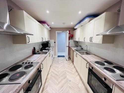 a kitchen with white cabinets and stainless steel appliances at LBT Property LTD in London