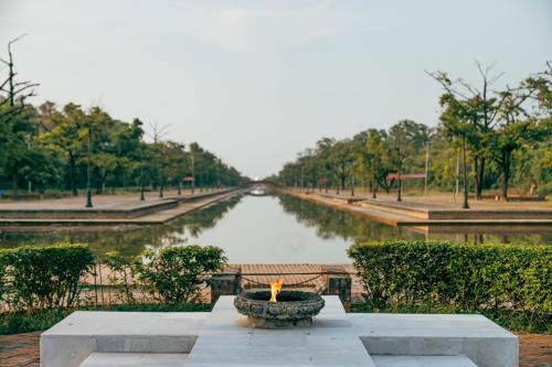 a view of a river with a candle in a fountain at Hokke Lumbini in Lumbini