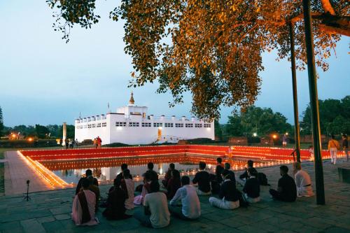 a group of people sitting in front of a boat at Hokke Lumbini in Lumbini