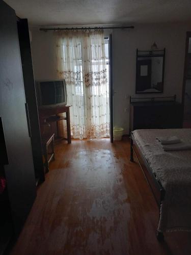 an empty room with a bed and a television at Pansion Angela in Skiathos Town