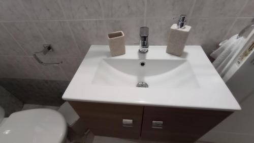a bathroom with a white sink and a toilet at Angela's Seaside Luxury Flat in Lefkandi Chalkidas