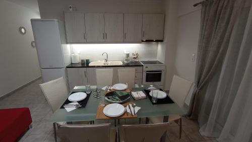 a kitchen with a table and chairs and a kitchen with a sink at Angela's Seaside Luxury Flat in Lefkandi Chalkidas