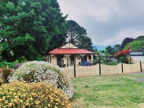 a small house with a fence in a yard at A Daylesford 2br ABELIA Cottage walk 2 town sleep 5 in Daylesford