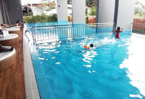 two children playing in a large swimming pool at Ductaigallery's Apt& Pool-Good view in Ấp Phú Thọ