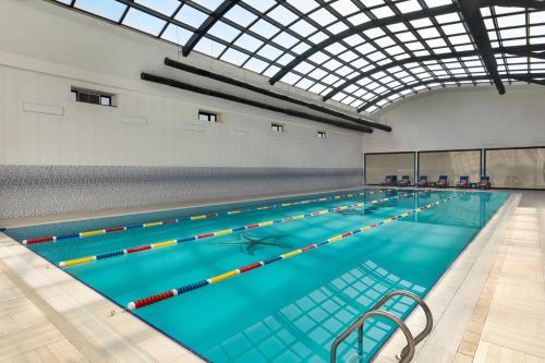 a large indoor swimming pool with a glass ceiling at Wyndham Baku in Baku