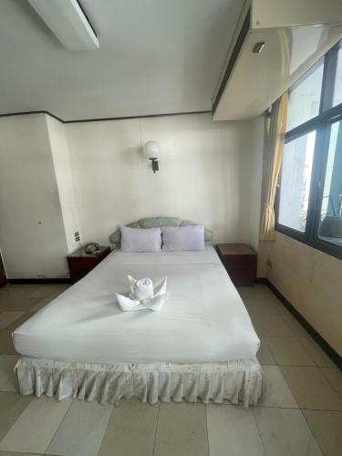 a bedroom with a large white bed with a flower on it at Residence Inn Pattaya in Pattaya Central