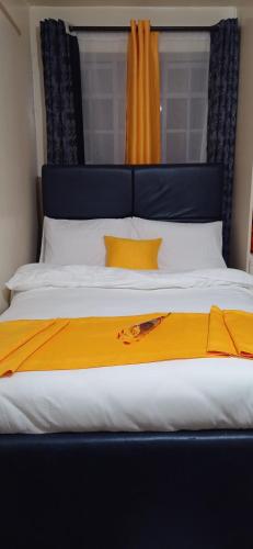 ein großes Bett mit gelber Decke drauf in der Unterkunft SGH Furnished Studio Homes South B Nairobi in Nairobi