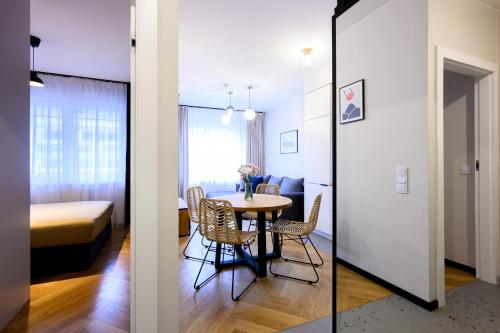 a room with a table and chairs and a bedroom at Native Apartments Barska 69 in Krakow