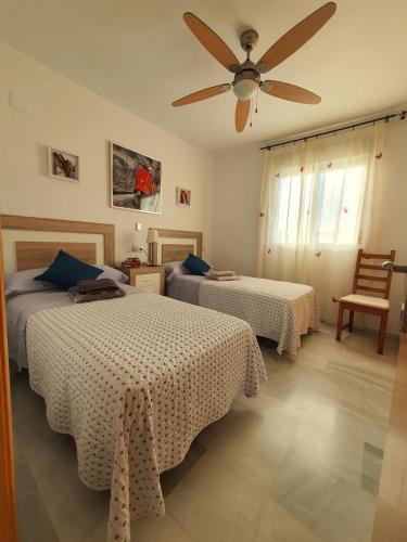una camera con 2 letti e un ventilatore a soffitto di Apartamento en El Toyo a El Toyo