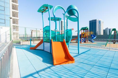 a playground with a slide and slides at S Plaza Suites Hotel in Seef