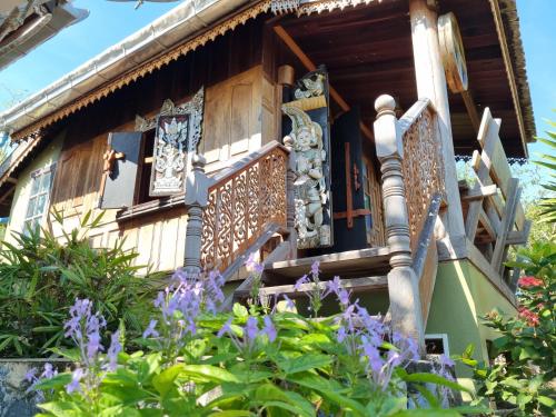a house with a balcony and purple flowers at Hello Sichang Bungalow in Ko Si Chang