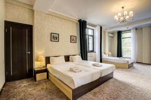 1 Schlafzimmer mit einem großen Bett und einem Badezimmer in der Unterkunft Hotel Touristan Bishkek in Bischkek