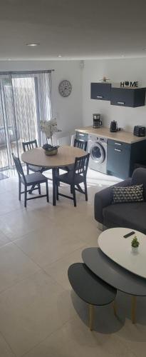 un salon avec une table et des chaises et une cuisine dans l'établissement Le Béluga spa Aéroport Nantes Bouguenais Rezé, à Bouguenais