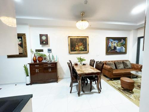 a living room with a table and a couch at Ductaigallery's Apt& Pool-Good view in Ấp Phú Thọ