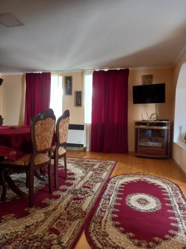 een woonkamer met een tafel en stoelen en een tapijt bij Tskaltubo Apartment Meri in Tskaltubo