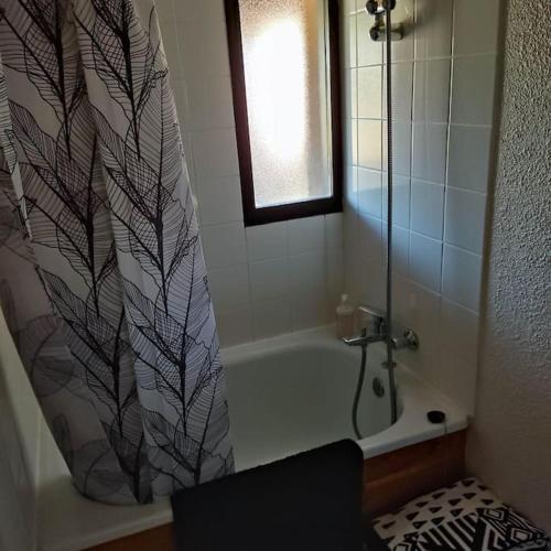 a bathroom with a shower curtain and a bath tub at Studio maubuisson lac/océan 4/6 personnes in Carcans