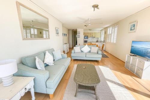 a living room with a couch and a tv at Harbourside 13 fantastic waterfront unit in Soldiers Point