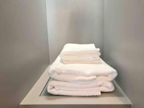 una pila de toallas blancas sentadas en un estante en 1BR Luxury Condo 50m to Thonglor BTS station en Bangkok
