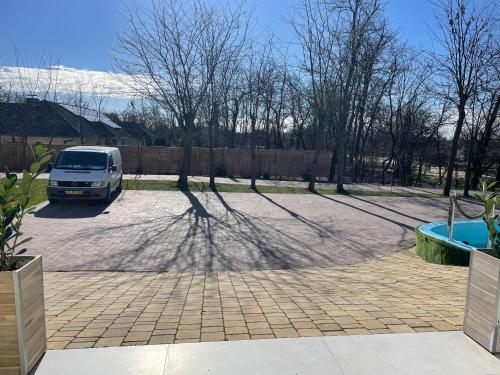 una furgoneta estacionada en un estacionamiento con una sombra en Reneszánsz Vendégház en Debrecen