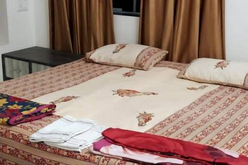 a bed with clothes on top of it at AG House Daman holiday Home apartment in Daman