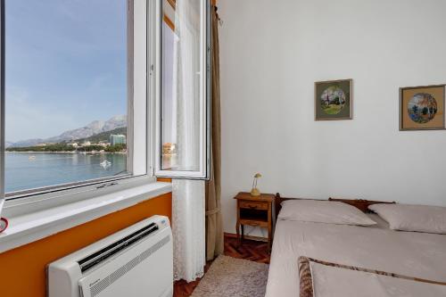 a bedroom with a bed and a window with a view at Beach rooms Riviera - Žuta Kuća in Makarska