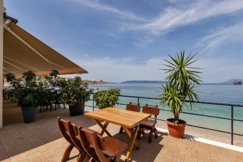 a table and chairs on a balcony with a view of the ocean at Beach rooms Riviera - Žuta Kuća in Makarska