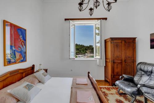 a bedroom with a bed and a chair and a window at Beach rooms Riviera - Žuta Kuća in Makarska