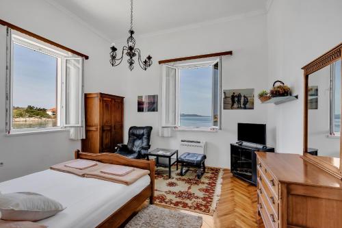 a bedroom with a bed and a desk and windows at Beach rooms Riviera - Žuta Kuća in Makarska