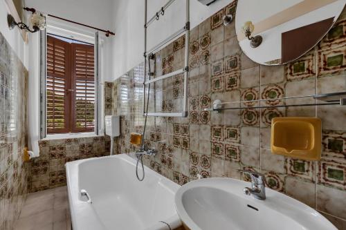 La salle de bains est pourvue d'un lavabo, de toilettes et d'un miroir. dans l'établissement Beach rooms Riviera - Žuta Kuća, à Makarska