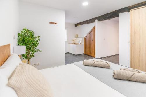 una camera da letto con un letto bianco con due cuscini sopra di Precioso piso estilo rústico a 10 min de Santander a Camargo