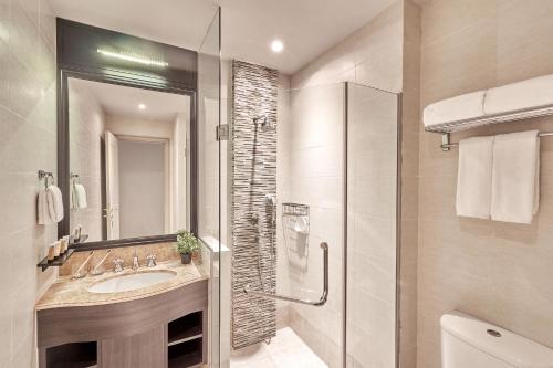 Adina Serviced Apartments Singapore Orchard في سنغافورة: حمام مع حوض ودش