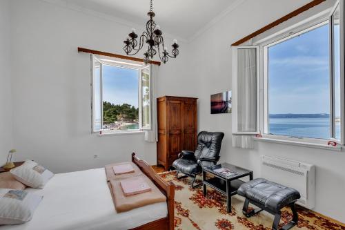 a bedroom with a bed and two windows at Beach rooms Riviera - Žuta Kuća in Makarska