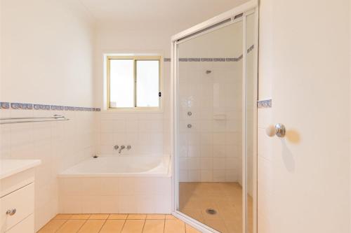 a bathroom with a bath tub and a shower stall at Ocean View Anna Bay in Anna Bay