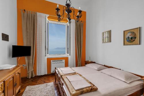 a bedroom with a bed and a large window at Beach rooms Riviera - Žuta Kuća in Makarska