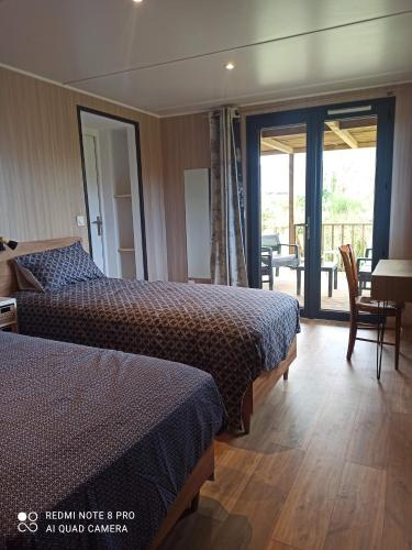 PenvénanにあるKalon Vreizhのベッド2台とバルコニーが備わるホテルルームです。