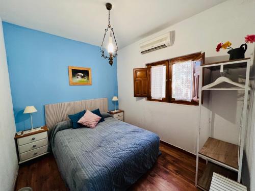 1 dormitorio con paredes azules, 1 cama y ventana en Casa Rural Serafïn, Pet Friendly, en Renera