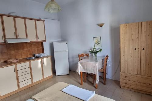 una cucina con tavolo e frigorifero bianco di Aspartia a Naxos Chora