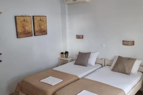 2 Betten in einem Zimmer mit weißen Wänden in der Unterkunft Aspartia in Naxos Chora