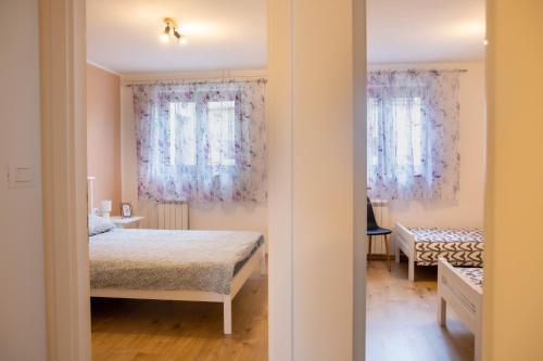 a bedroom with a bed and two windows with curtains at Apartment Fioretti in Bale