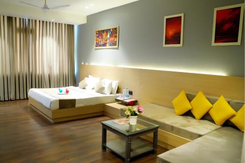 Hotel Classic Residency في كالكا: غرفه فندقيه بسرير واريكه