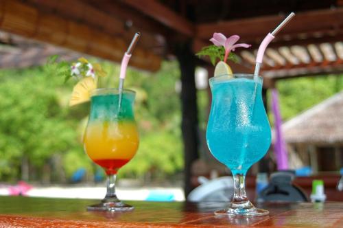 Pulau Mansuarにあるラジャ アンパット ダイブ ロッジのカクテル2杯(テーブルの上に座る)