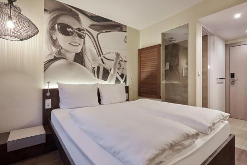 a bed with a picture of a woman wearing sunglasses at Hotel GIO in Munich