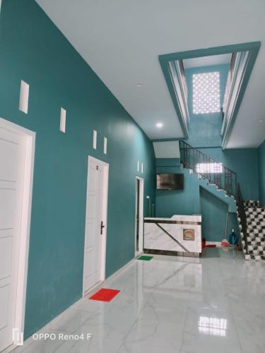 ein leeres Zimmer mit blauen Wänden und einer Treppe in der Unterkunft PENGINAPAN HKHAN in Ternate