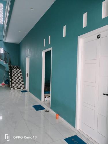 Zimmer mit einer weißen Tür und einer blauen Wand in der Unterkunft PENGINAPAN HKHAN in Ternate