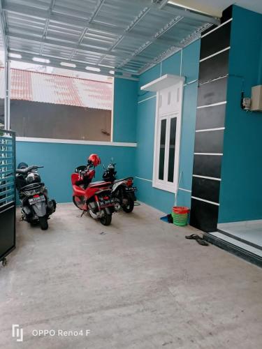 twee motorfietsen geparkeerd in een kamer met blauwe muren bij PENGINAPAN HKHAN in Ternate