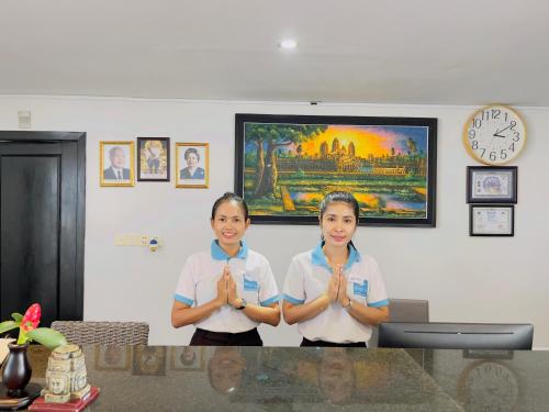 two girls standing in a room with their hands in prayer at Mary Beach Hotel & Resort in Sihanoukville