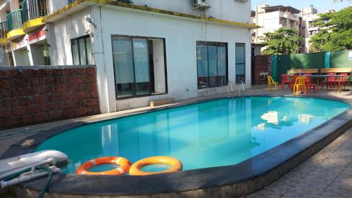a large blue swimming pool with orange tubes in it at CBC Residency, Karjat in Karjat